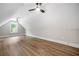 Attic space with two ceiling fans, angled ceilings, and wood flooring at 321 Evie Ln, Canton, GA 30115