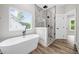 Primary bath with soaking tub, frameless shower, and picture window at 321 Evie Ln, Canton, GA 30115