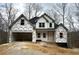 A new two-story home shows modern vertical siding, dark roof, and an attached two-car garage at 321 Evie Ln, Canton, GA 30115