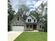 Charming two-story home featuring stone accents, a well-manicured lawn, and an attached two-car garage at 321 Evie Ln, Canton, GA 30115