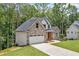 Two-story home with stone and siding, an attached garage, and a well-manicured lawn at 321 Evie Ln, Canton, GA 30115