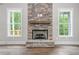 Close-up of the stunning stone fireplace, flanked by two windows offering natural light at 321 Evie Ln, Canton, GA 30115