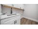 Laundry room features white cabinets, a marble countertop, and a black faucet at 321 Evie Ln, Canton, GA 30115
