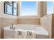 Relaxing bathroom featuring a corner soaking tub and tile surround at 3249 Shirecrest Ln, Dacula, GA 30019