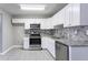 Renovated kitchen featuring white cabinets, granite countertops, and stainless steel appliances at 3578 Adkins Nw Rd, Atlanta, GA 30331