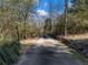 Private paved driveway winds through wooded area at 2402 Highway 138 Sw, Conyers, GA 30094