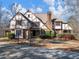 Tudor style home with brick and stucco exterior, landscaping, and driveway at 2402 Highway 138 Sw, Conyers, GA 30094