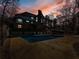 In-ground pool with surrounding patio, illuminated at dusk at 2402 Highway 138 Sw, Conyers, GA 30094
