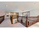 Upstairs hallway with wood railing and carpet at 2402 Highway 138 Sw, Conyers, GA 30094