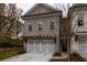 Brick front exterior of a two-story townhome with a two-car garage and pergola at 131 Wards Crossing Way # 19, Johns Creek, GA 30022