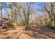 Wooded backyard with a sloped terrain and leaf-covered ground at 143 Longview Rd, Fayetteville, GA 30214