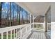 This covered back porch has white wooden posts, neutral paint, and overlooks a wooded area at 3251 Stoney Acres Nw Dr, Kennesaw, GA 30152
