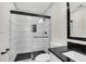 Modern bathroom featuring a glass shower with vertical tiles, black accents, and herringbone flooring at 3251 Stoney Acres Nw Dr, Kennesaw, GA 30152