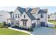 Traditional home with a lush green lawn, a covered porch, and a three-car garage at 4973 Concert Ln, Marietta, GA 30066