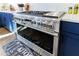Stainless steel oven with six burner cooktop and brass knobs offers a modern look with a chevron backsplash behind the range at 4973 Concert Ln, Marietta, GA 30066