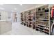 Expansive walk-in closet with custom shelving, an island, and bench seating at 4973 Concert Ln, Marietta, GA 30066