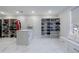 Expansive walk-in closet with custom shelving, an island, and bench seating at 4973 Concert Ln, Marietta, GA 30066