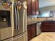 Stainless steel refrigerator in a kitchen with dark wood cabinets and granite countertops at 709 Chapman St, Jonesboro, GA 30238