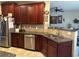 Spacious kitchen with dark wood cabinets, granite countertops, and stainless steel appliances at 709 Chapman St, Jonesboro, GA 30238