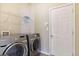 Laundry room with washer and dryer and overhead shelving at 709 Chapman St, Jonesboro, GA 30238