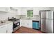 Bright kitchen features white cabinets, stainless appliances, granite counters, and wood floors at 1120 Starline Se Dr, Smyrna, GA 30080