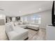 Bright living room with L-shaped sofa and hardwood floors, open to kitchen at 12 Enclave Blvd, Covington, GA 30014