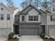 Charming townhome featuring a stone front, gray siding, and a two-car garage at 3266 Spicy Cedar Ln, Lithonia, GA 30038