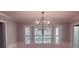 Elegant dining room with chandelier, wainscoting, and bay window with shutters at 1030 Lake Haynes Ne Dr, Conyers, GA 30012