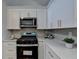Modern kitchen features white cabinets, stainless steel appliances and quartz countertops at 2490 Woodfern Ct, Marietta, GA 30062