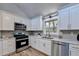 Updated kitchen with white cabinets, stainless steel appliances, and quartz countertops at 2490 Woodfern Ct, Marietta, GA 30062