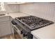 Stainless steel gas cooktop with black grates, installed on a white quartz countertop at 3819 Landgraf Cv, Decatur, GA 30034