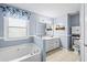 Bathroom with double vanity, soaking tub, and light blue walls at 775 Holcombe Woods Ct, Auburn, GA 30011