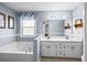 Bathroom with double vanity, soaking tub, and light blue walls at 775 Holcombe Woods Ct, Auburn, GA 30011