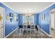 Bright dining room with blue walls, chandelier, and white table at 775 Holcombe Woods Ct, Auburn, GA 30011