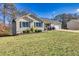 House with a well-maintained lawn, attached garage, and neutral color scheme at 775 Holcombe Woods Ct, Auburn, GA 30011
