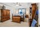 Main bedroom with large bed, wood furniture, and ceiling fan at 775 Holcombe Woods Ct, Auburn, GA 30011