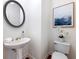 Stylish powder room featuring pedestal sink, round mirror, and elegant decor at 2750 Olde Towne Pkwy, Duluth, GA 30097