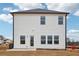 Rear exterior view of a two-story white home, showing the back windows, door, and small patio at 2024 Avalon Rdg, Conyers, GA 30013