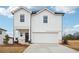 Two-story home with white siding, a two-car garage, and a well-manicured front lawn at 2024 Avalon Rdg, Conyers, GA 30013