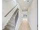 Hallway with carpeted stairs and wood-look floors, bathed in natural light at 2024 Avalon Rdg, Conyers, GA 30013