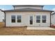 This backyard features a small concrete patio and exterior access door on a neutral-colored home at 2026 Avalon Rdg, Conyers, GA 30013