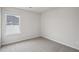 Empty bedroom with neutral walls, neutral carpeting, and natural light streaming through the window at 2026 Avalon Rdg, Conyers, GA 30013