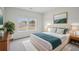 A beautifully decorated bedroom with a teal blanket, two windows and potted plant adding life to the space at 2026 Avalon Rdg, Conyers, GA 30013