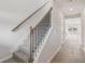 Carpeted stairs with wood and metal railings lead to upper level, with light hardwood floors in the hallway at 2026 Avalon Rdg, Conyers, GA 30013