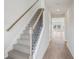 Carpeted stairs with wood and metal railings leading to the upper level, with views of the bright hallway at 2026 Avalon Rdg, Conyers, GA 30013