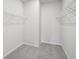 Carpeted walk-in closet with white walls and shelving for clothing and accessories at 2026 Avalon Rdg, Conyers, GA 30013