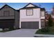 Charming two-story home with a brick and white facade, a dark grey garage door, and well-maintained landscaping at 2121 Avalon Rdg, Conyers, GA 30013
