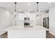 Bright kitchen with stainless steel appliances, white cabinets, large island and pendant lighting at 2028 Avalon Rdg, Conyers, GA 30013