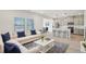 Staged living room open to modern kitchen with large windows and wood flooring at 2032 Avalon Rdg, Conyers, GA 30013