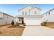 Charming two-story home with light gray siding, a two-car garage, and a neatly landscaped front yard at 2036 Avalon Rdg, Conyers, GA 30013
